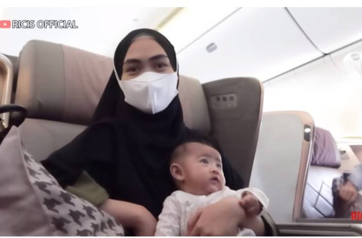 Ria Ricis dan Baby Moana di pesawat menuju Singapura. (Foto: Tangkapan layar YouTube Ria Ricis Official)